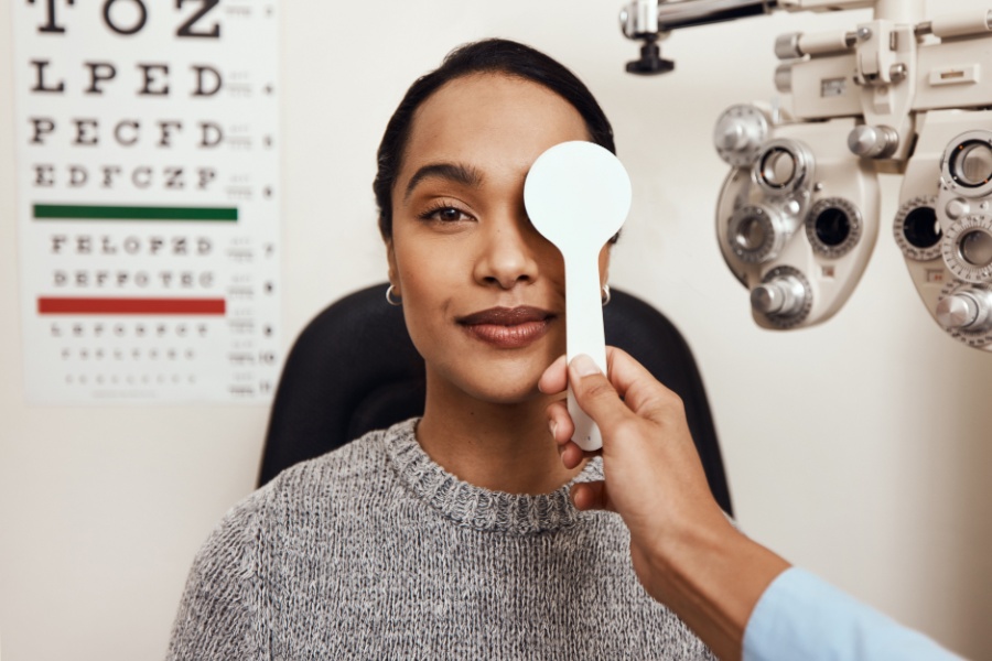 Woman taking eye exam with one eye covered.